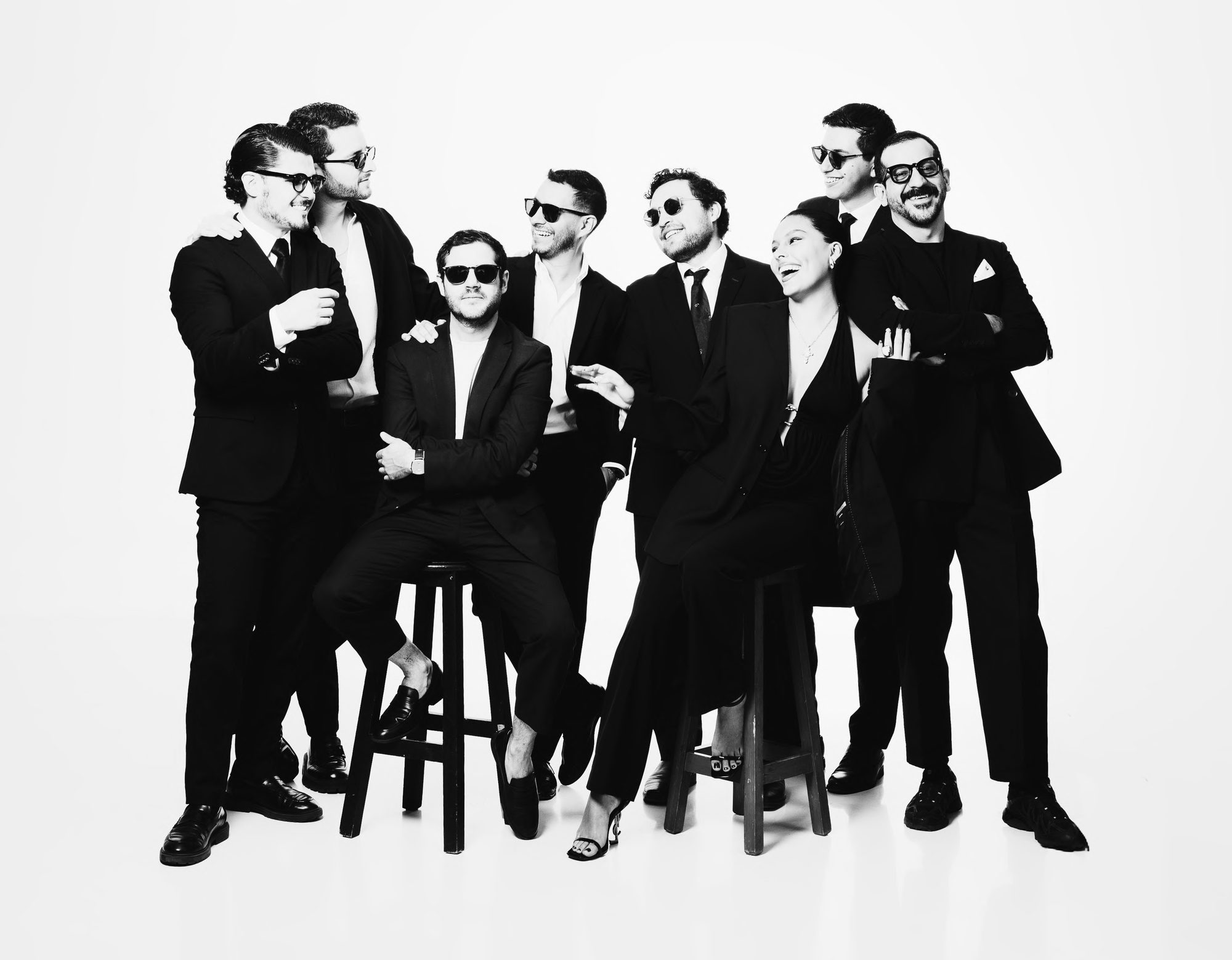 The CAPITAL DJs team in black suits and dark sunglasses